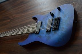 blue guitar on a wooden surface