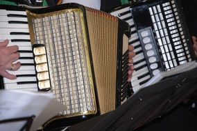 two accordions in the hands of close up