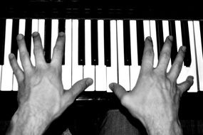 manâs Hands on piano keys