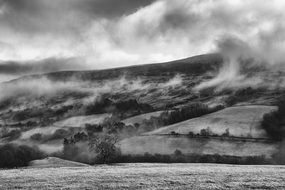 Black and white photo of fog over the countryside