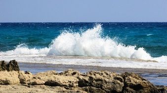 waves are breaking on stones on beautiful and colorful waterscape