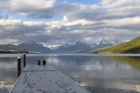 two people on a pier at lake mcdonald