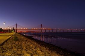 distant view of the bridge in lisbon at dusk