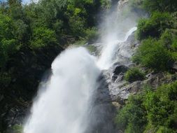 noisy stormy waterfall among greenery