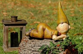 figurine of a lying man on a tree trunk