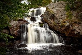 stream of waterfall on a rock in a park