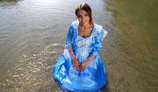 girl in princess dress sitting in the water