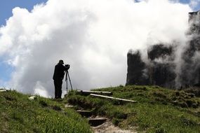 Photographer on mountain at clouds