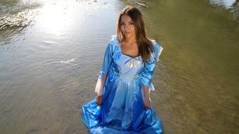 girl in blue princess dress in the water