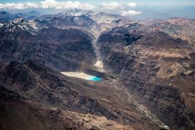 view from a height of a turquoise lake among the mountains