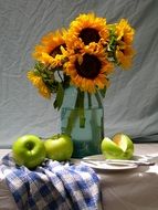 still life a bouquet of sunflowers and green apples