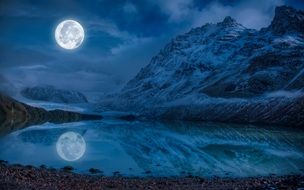 Moon and Rock nirroring on calm Water