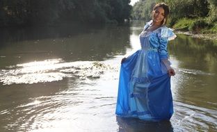 girl in a long dress standing in lake
