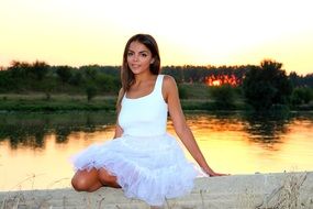 girl in a white dress at sunset near the lake