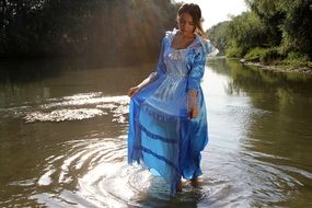 girl in a long blue dress on the lake