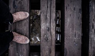 feet in shoes on a wooden bridge