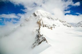 snowy peaks of mountains in a cloud haze