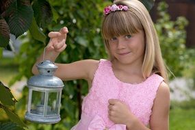 young girl with lantern in the garden close-up on blurred background