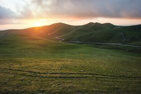 distant view of sunlight over green hills