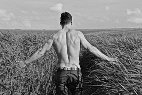 black and white photo of a man on a wheat field