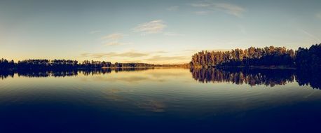 sunset is reflected in the waters of the lake