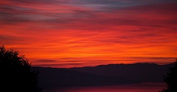 Landscape of the beautiful red and orange sunset above the landscape with hills