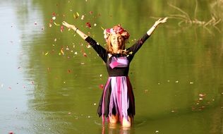 pretty woman in wreath standing in water