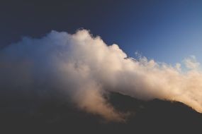 white clouds on top of a mountain