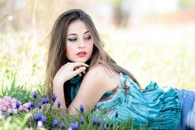 girl in a blue dress on a glade with hyacinths