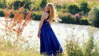 charming Girl Blonde near the water on a blurred background