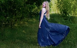 girl in blue dress on a green meadow