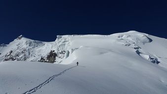man cross-country skiing on top of the Alps on a sunny day