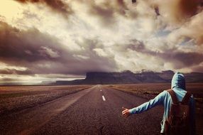wanderer on the road on a cloudy day