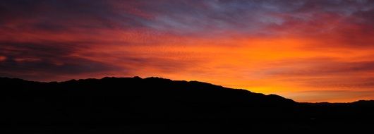 fiery sunset over the dark mountains