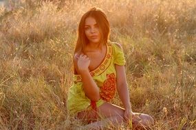 seductive girl on the grass in the rays of sunset