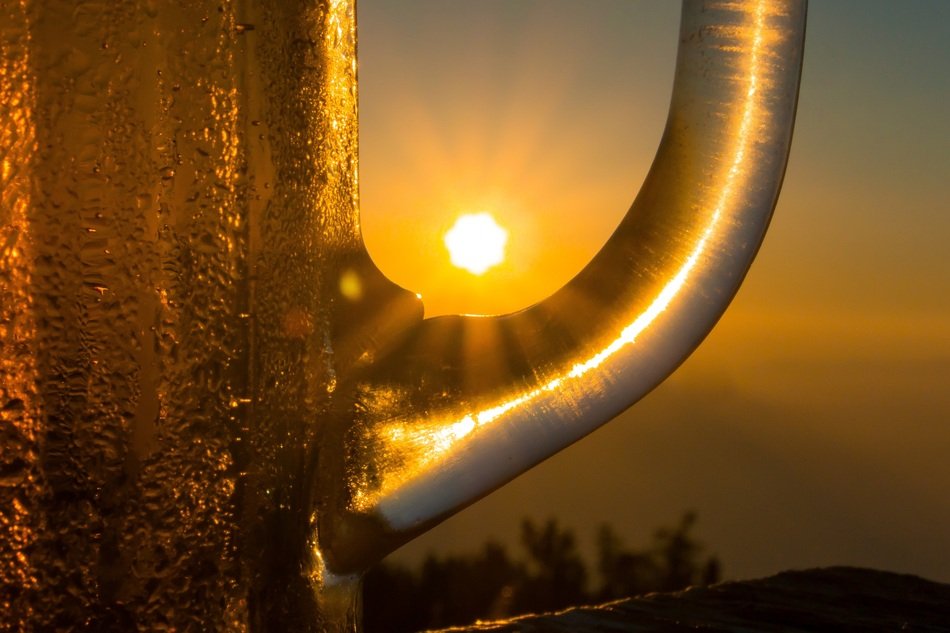 the sun is in the handle of a mug of beer
