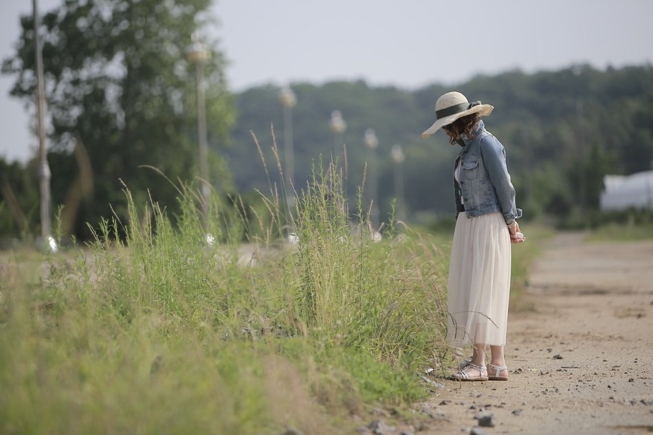 girl walks near the weeds on the street