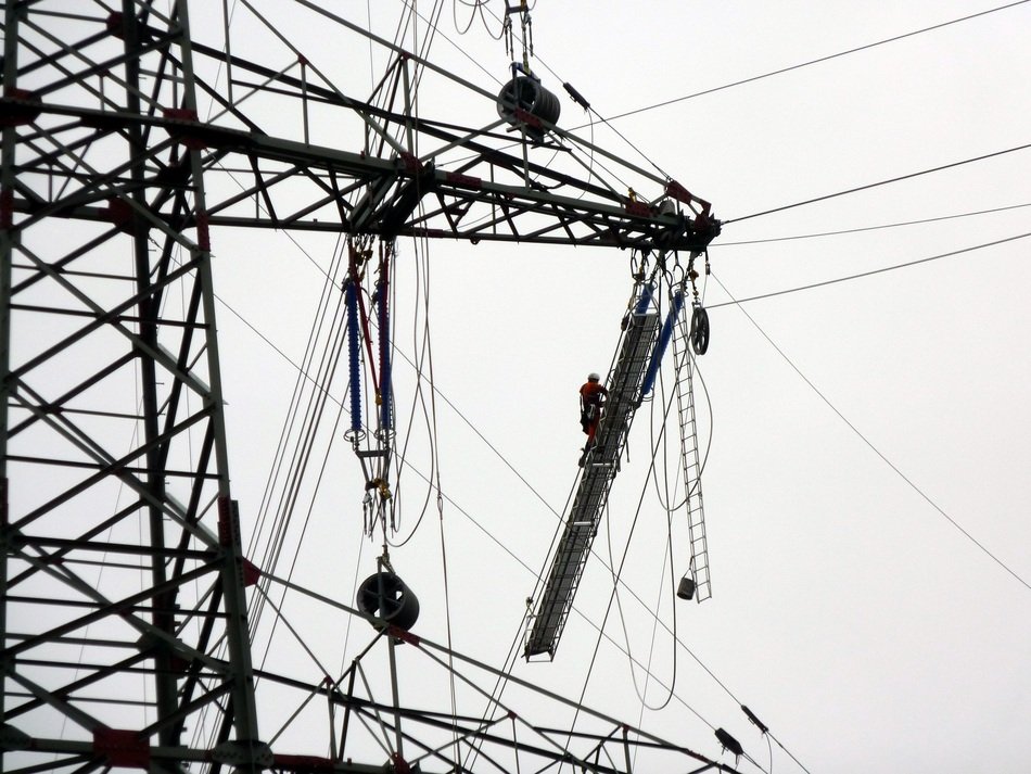 Black and white pole with live wires at background with the sky