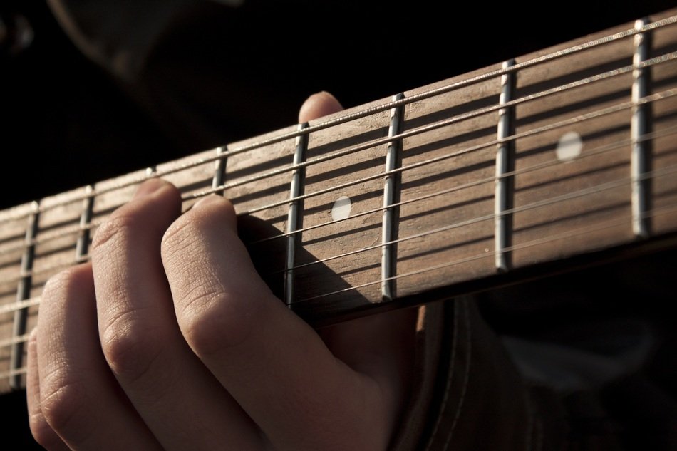 the fingers on the guitar