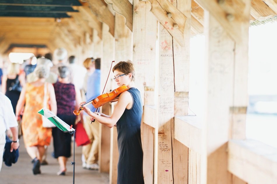 Violinist girl play on the woodeb bridge