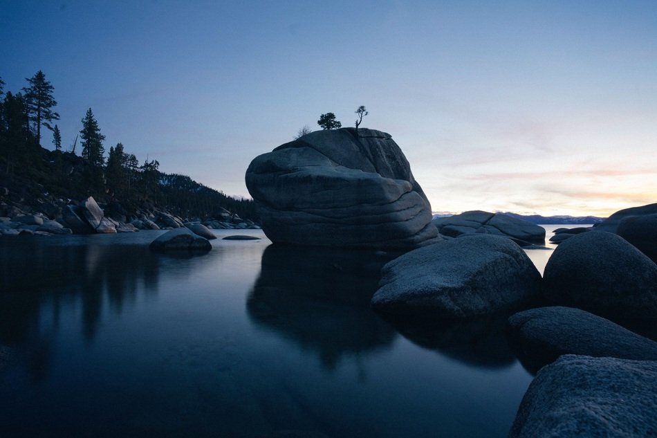 evening photo of boulders by the lake