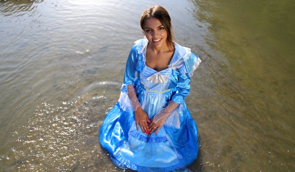 girl in princess dress sitting in the water