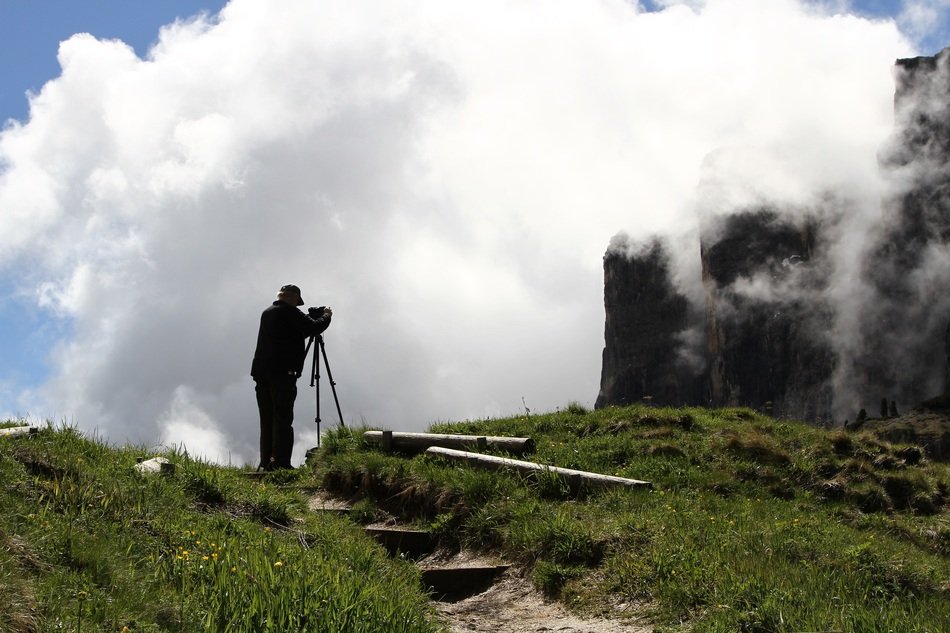 Photographer on mountain at clouds