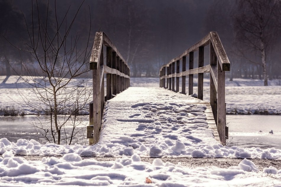 wooden bridge over the river in winter