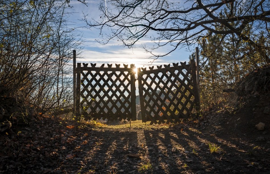 lattice gates in wire fence in countryside at sunset