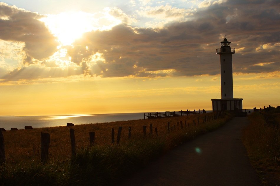 distant view of the lighthouse at yellow sunset