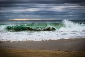 green ocean waves during a surf on the beach
