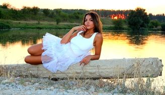 girl sitting by the lake at sunset