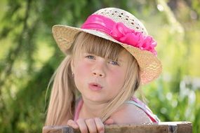 Girl in a straw hat with a pink bow