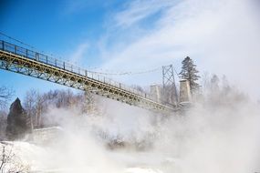 landscape of waterfall and bridge in mist